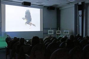 Artysta fotografik Tomasz Kłosowski wygłaszający swoją prelekcję na temat przyrody biebrzańskiej w sali wykładowej.