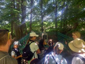 Młodzi uczestnicy wycieczki z przewodnikiem BbPN przy ogrodzonym krzyżu na jednej z wydm Grzęd.