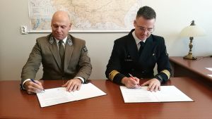 Pan dyrektor BbPN i i Pan dyrektor Delegatury w Giżycku UŻŚ siedzący przy stole, w trakcie podpisywania dokumentów...