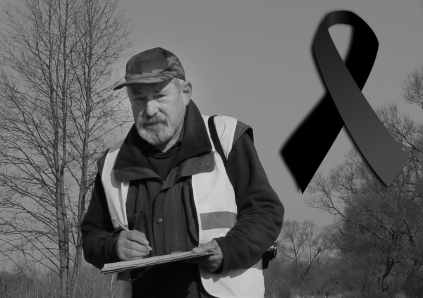 Zdjęcie Pana Adama Chwalińskiego w stroju służbowym w terenie z notatnikiem w rękach.